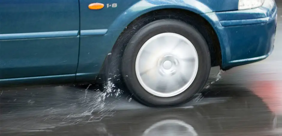 Automobile tires spinning while driving through rain