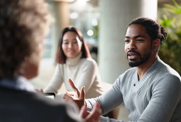 Man discussing if he needs life insurance to two women inside an office environment